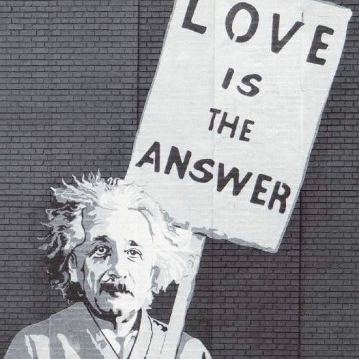 Graffiti von Albert Einstein, der ein Schild mit der Aufschrift "Love is the answer" hochhält. Methaphorisch für das Wohlwollen und die Liebe, die belastete Beziehungen funktionieren lassen.