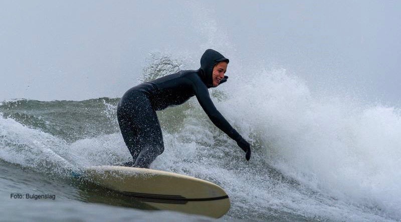 Frau surft in kaltem Wasser